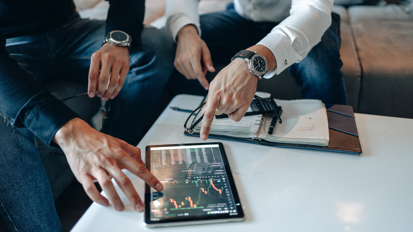 Hands Pointing the Screen of a Tablet with Crypto Graph